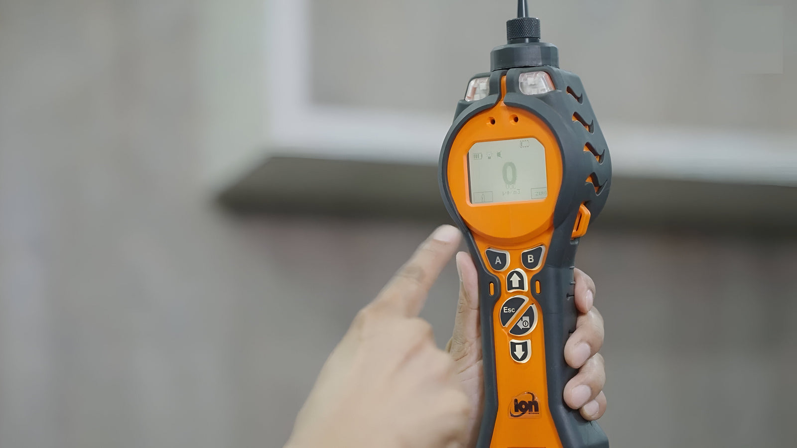 Handheld air quality monitoring device with digital display and control buttons for environmental testing